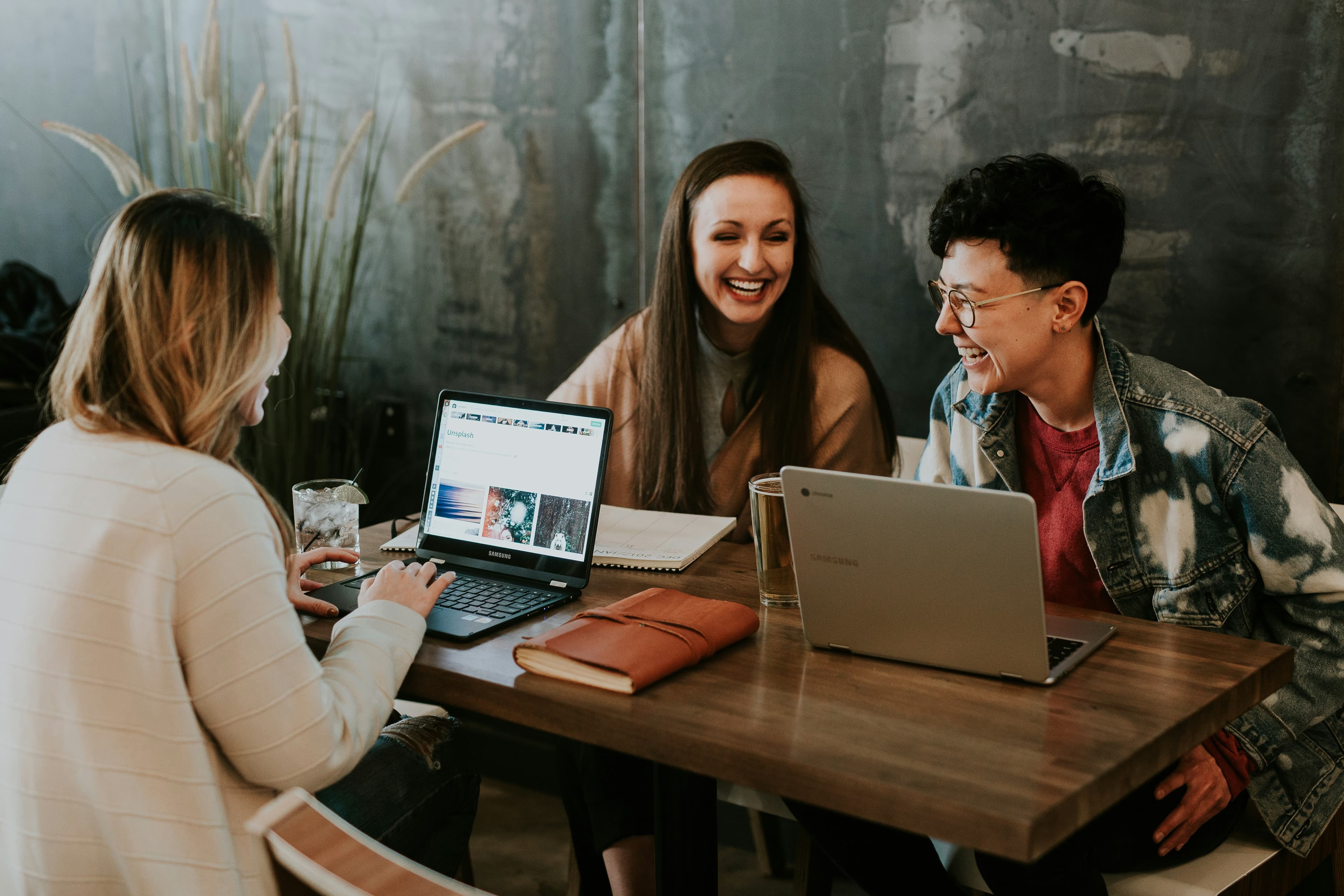 People collaborating around a table with laptops